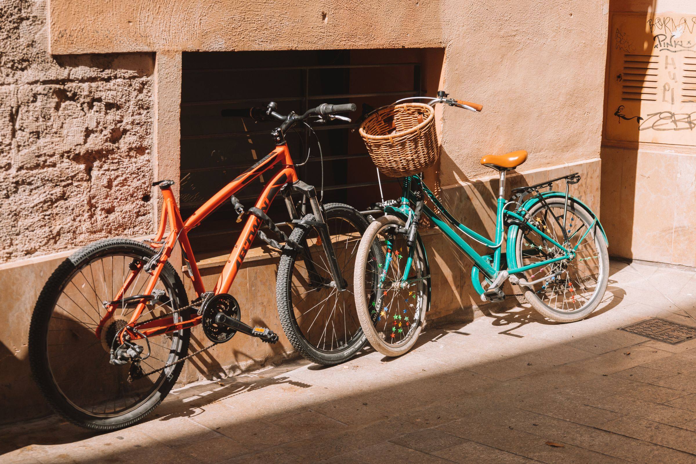 Bicicletas apoyadas en la pared de una calle